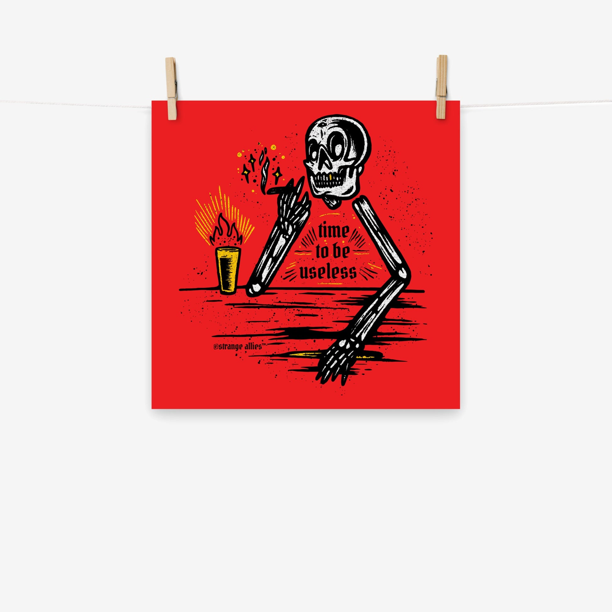 Useless Giclée Print features a black-and-white skeleton with a smoking joint and drink, captioned 'time to be useless.' Available in multiple sizes, it embodies laid-back irreverence.