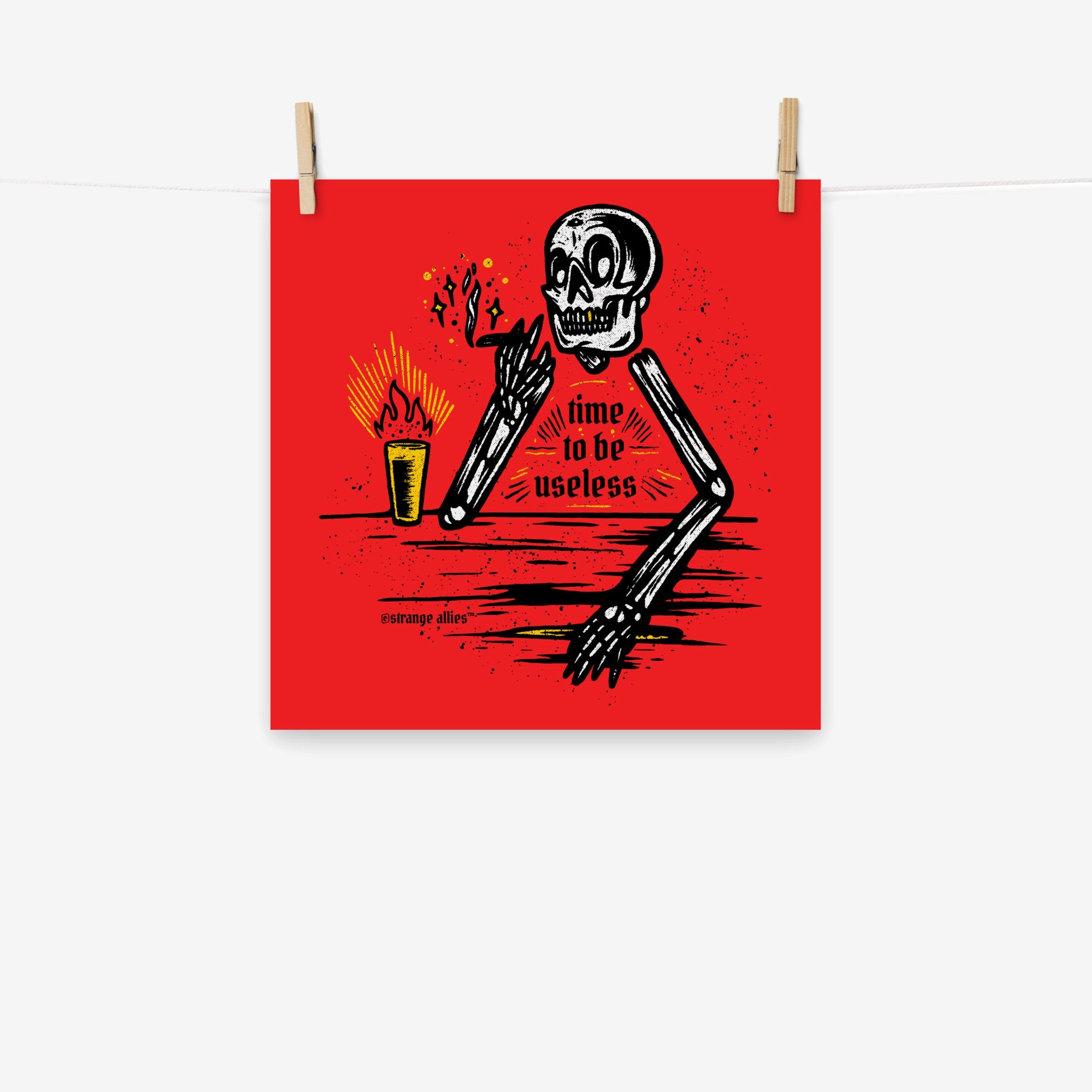 Useless Giclée Print features a black-and-white skeleton with a smoking joint and drink, captioned 'time to be useless.' Available in multiple sizes, it embodies laid-back irreverence.