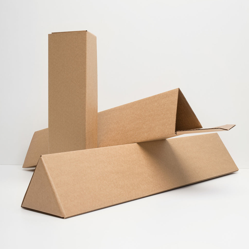 Three kraft cardboard triangular prisms, used for packaging, are shown with one upright, one flat, and one partially open, used for shipping the Useless Giclée Print in multiple sizes.