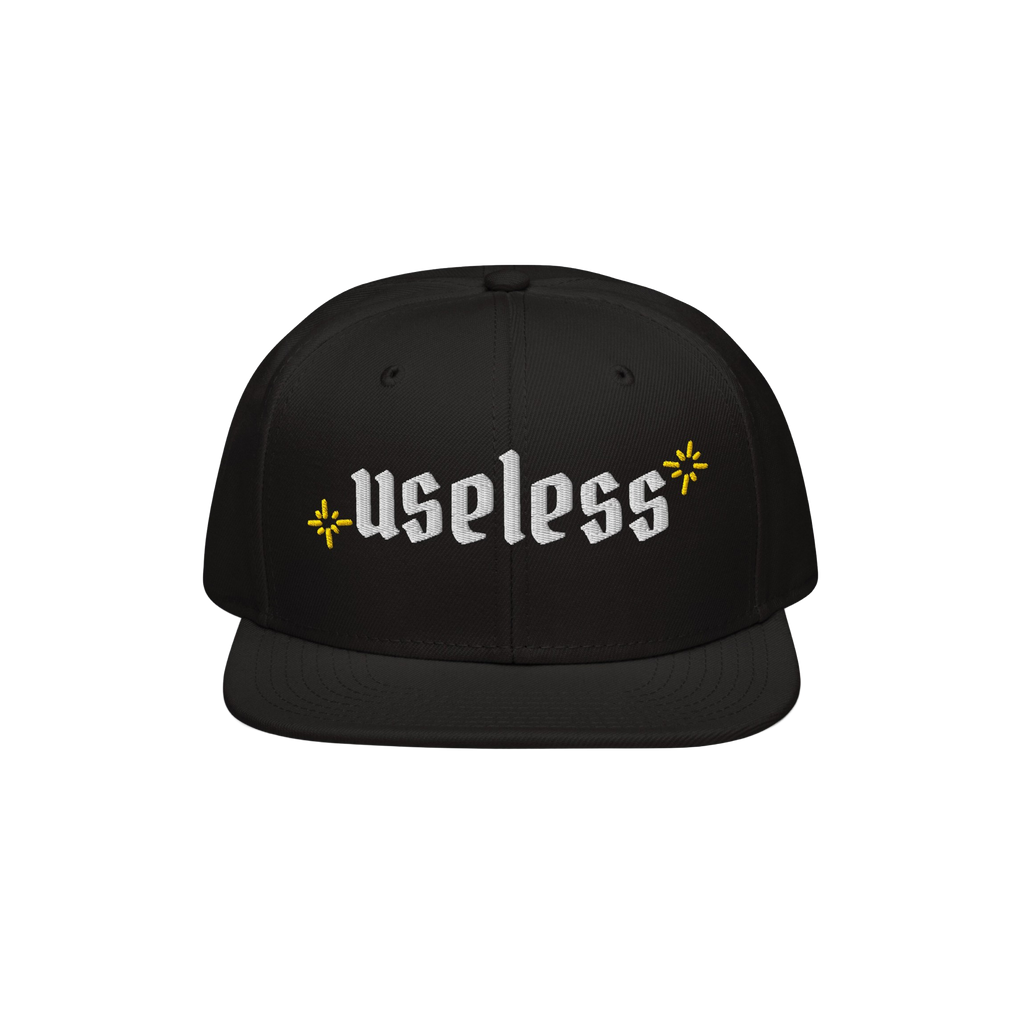 The Useless Hat features a flat-bill snapback design, with useless embroidered in white Old English font, flanked by yellow s