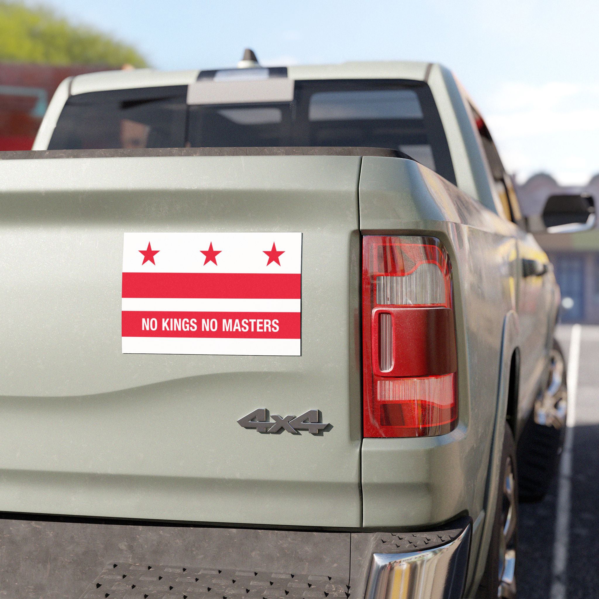 Washington DC Flag No Kings Sticker & Magnet on a light-green pickup truck's tailgate, featuring the flag's design with protest text, showcasing a stand against power. Tailgate, taillight, and bumper visible.