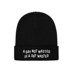 Black Wasted Days Hat with rib-knit design and folded cuff, featuring bold white embroidery: A DAY NOT WASTED IS A DAY WASTED