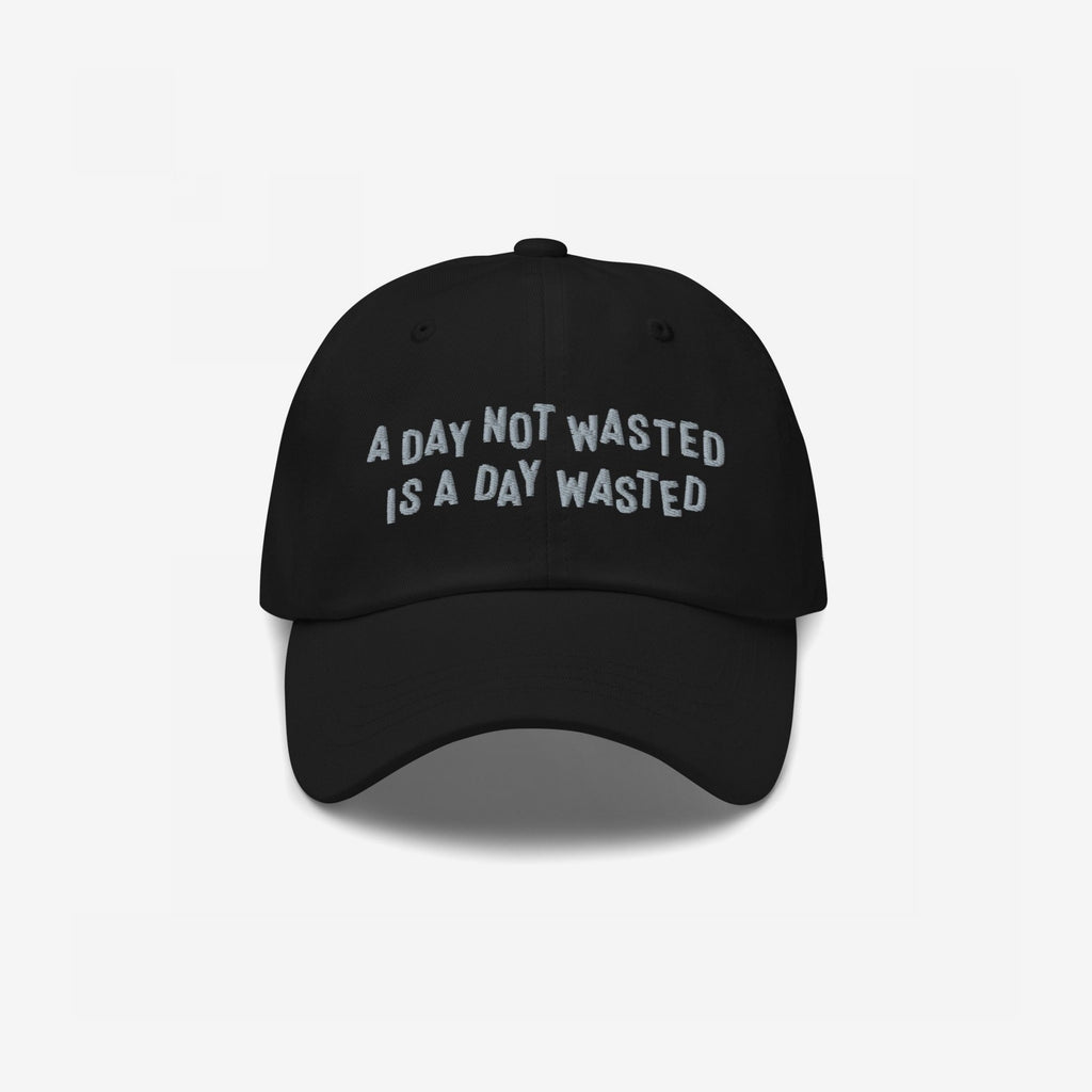 Wasted Days Hat featuring bold embroidery with the phrase “A DAY NOT WASTED IS A DAY WASTED” on a black cap, embodying a carefree, rebellious spirit perfect for endless adventures.