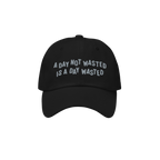 Wasted Days Hat featuring bold embroidery with the phrase “A DAY NOT WASTED IS A DAY WASTED” on a black cap, embodying a 