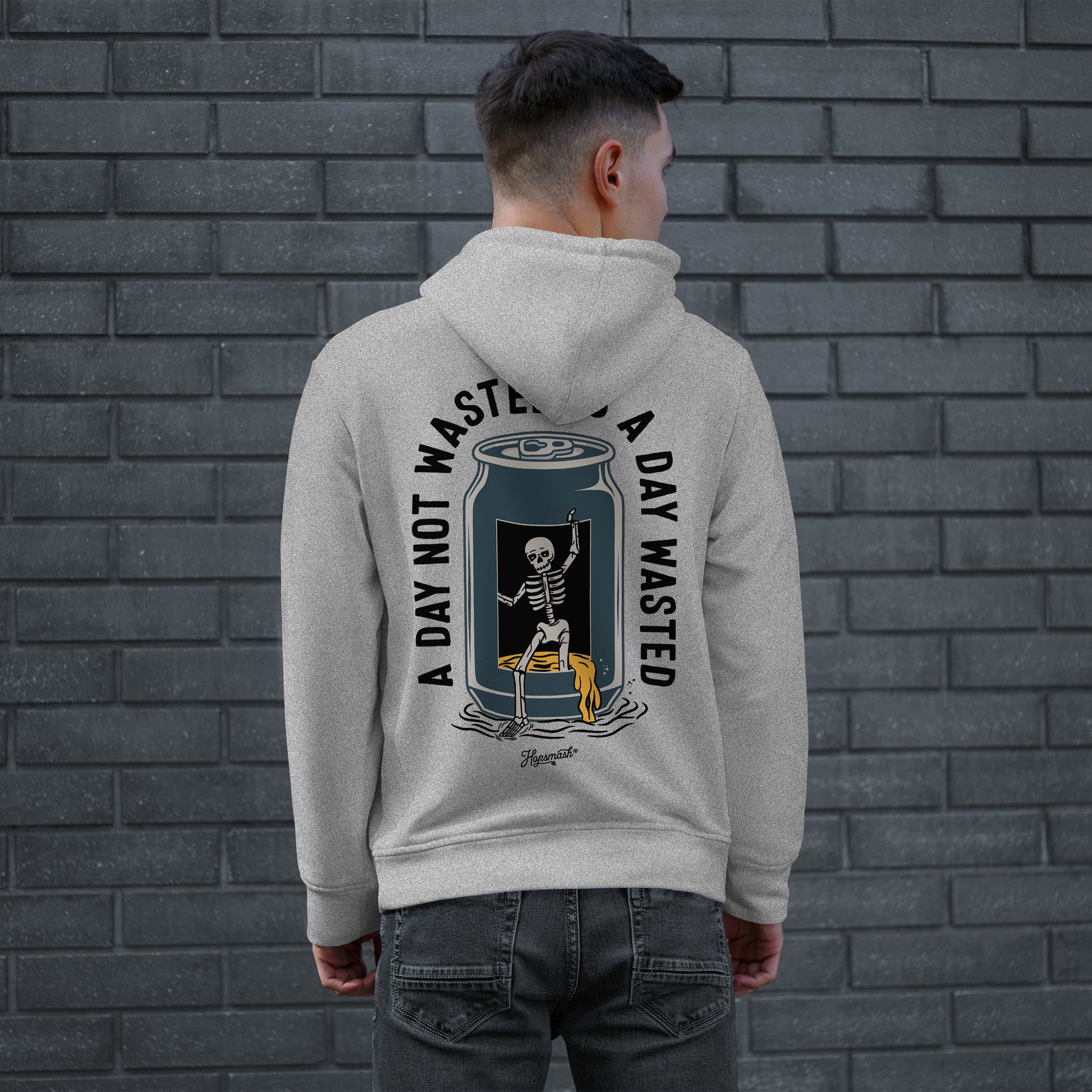 Young man models the Wasted Days Hoodie & Sweatshirt, featuring a skeleton escaping a soda can with the phrases “A DAY NOT WASTED” and “A DAY WASTED” on the back.