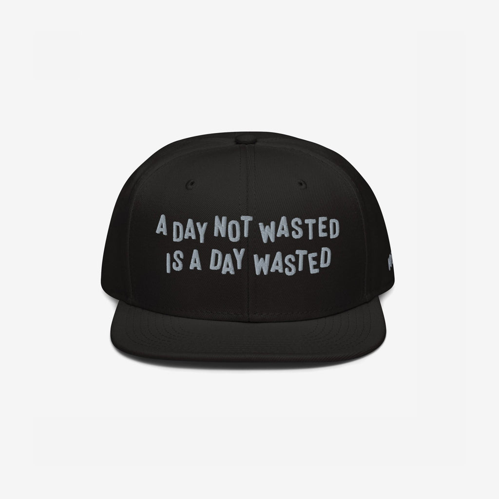 The Wasted Days Hat features bold white embroidery stating, A Day Not Wasted Is A Day Wasted, on a black snapback, embodying a carefree, unapologetic lifestyle ideal for vibrant, inclusive gatherings.