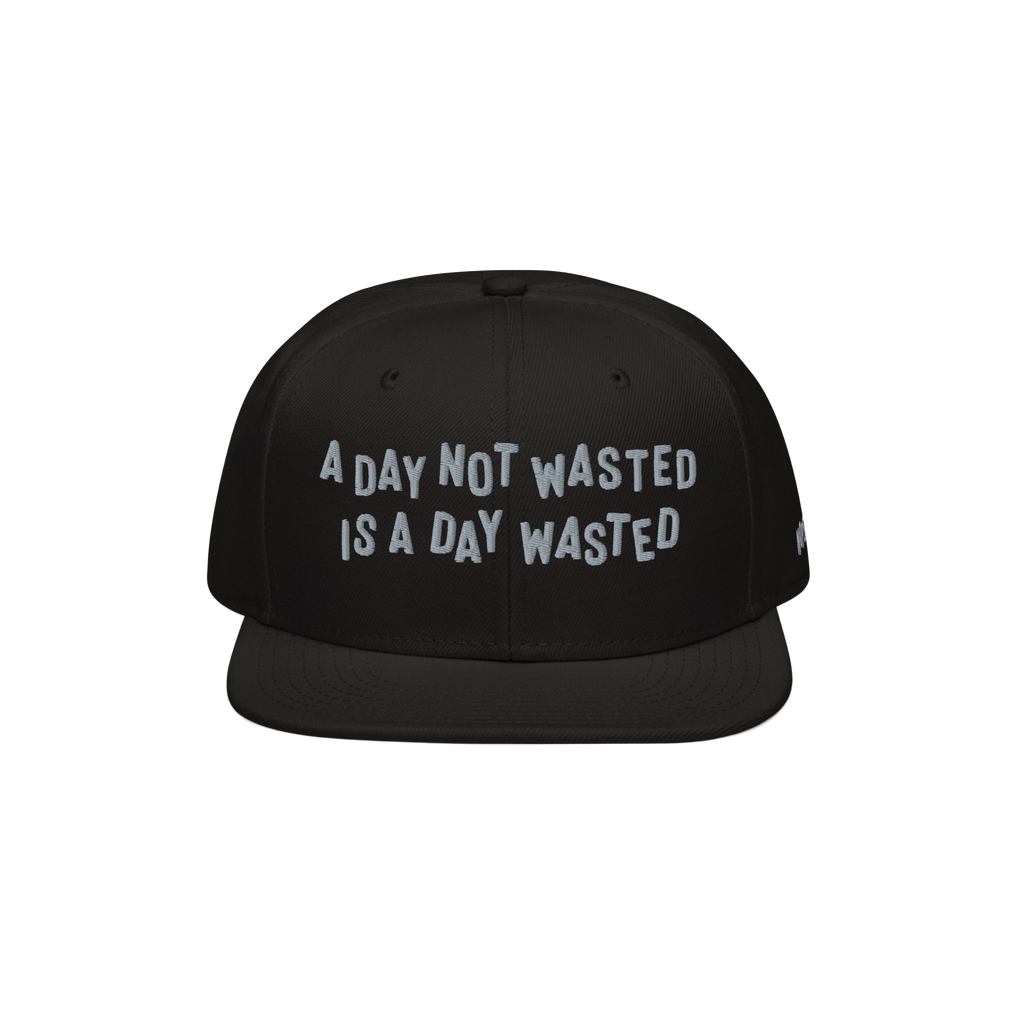 The Wasted Days Hat features bold white embroidery stating, A Day Not Wasted Is A Day Wasted, on a black snapback, embodying 