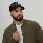 Close-up of a bearded man wearing the Wasted Days Hat, a black trucker-style cap featuring the bold slogan “A DAY NOT WASTED IS A DAY WASTED” in white, embodying carefree, adventurous spirit.