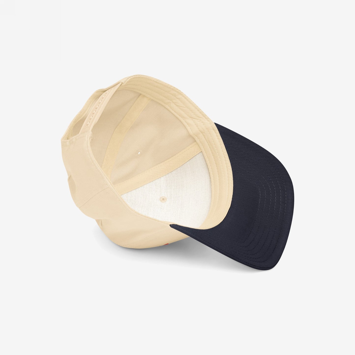 Watch List Hat displayed sideways, showcasing its simple design with a beige crown and navy visor, highlighting its role as a subtle yet bold statement piece for politically conscious wearers.