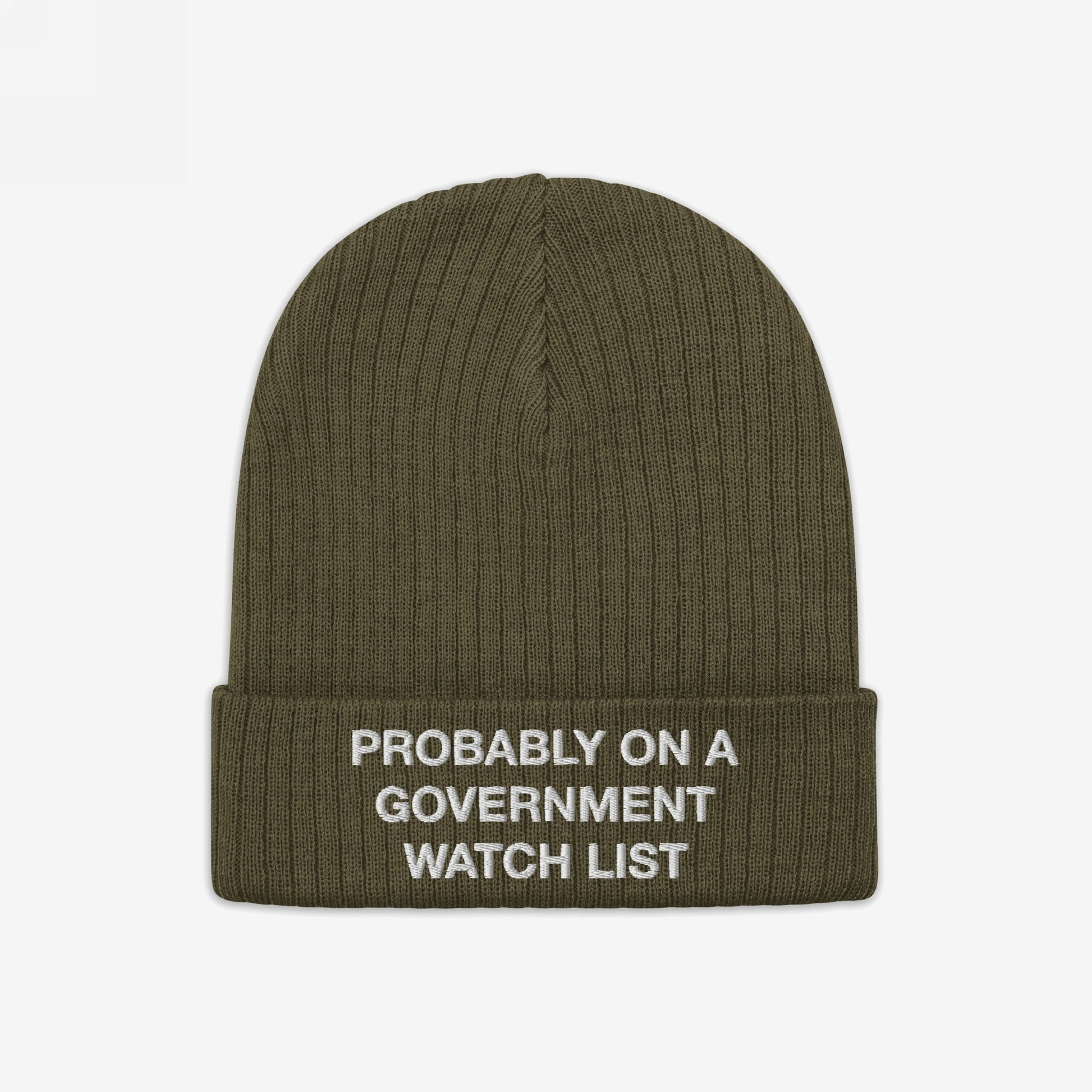 The Watch List Hat features an olive-green, ribbed knit design with a folded cuff, embroidered with “PROBABLY ON A GOVERNMENT WATCH LIST,” reflecting bold activism and individuality.