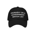 The Watch List Hat features a black baseball style with white embroidered text stating, PROBABLY ON A GOVERNMENT WATCH LIST, 
