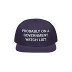 Watch List Hat: A dark navy snapback cap with white block letters, stating PROBABLY ON A GOVERNMENT WATCH LIST, embodying bol