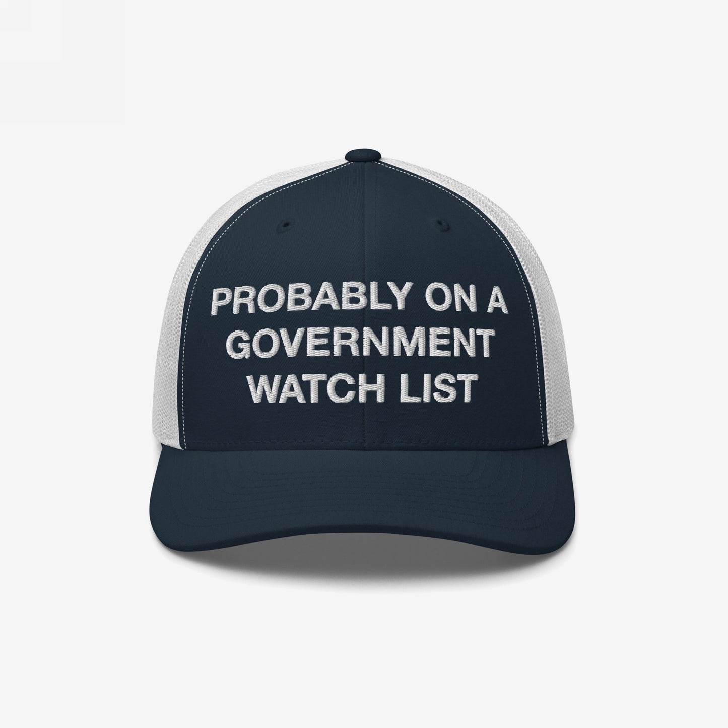 The Watch List Hat features a navy-blue trucker style with white mesh panels, showcasing PROBABLY ON A GOVERNMENT WATCH LIST in bold white letters, embodying protest and visibility.