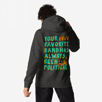Your Favorite Band Has Always Been Political Hoodie features bold teal and yellow text with orange raised-fist icons and a flame graphic on the back, worn by a person standing against a plain background.