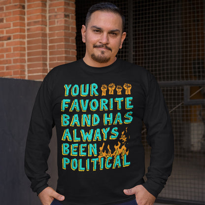 Man outdoors wearing Your Favorite Band Has Always Been Political long-sleeve T-shirt, featuring bold lettering, stylized fists, and flames. Reflects protest anthem energy and art as resistance.