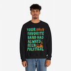 Young man in a black Your Favorite Band Has Always Been Political sweatshirt with colorful lettering, raised fists, and flame graphic. Perfect for fans of politically charged music.