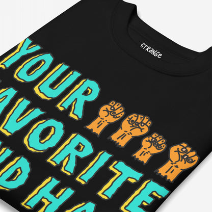 Folded black T-shirt featuring Your Favorite Band Has Always Been Political design in aqua and yellow with five orange fists, embodying a bold, rebellious statement against political ignorance.